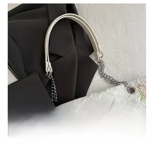 Detail of white quilted tote bag with colorful butterfly embroidery and chain strap