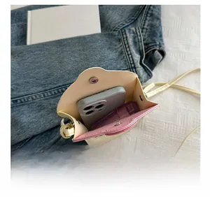 Detail view showing internal storage for a smartphone and makeup in a mini crossbody bag