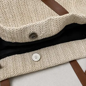 Detail showing the high-quality metal magnetic snap closure on a woven straw tote bag