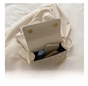 Interior view showing the storage capacity of the cream square crossbody bag with chain
