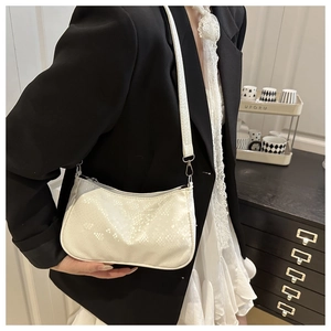 Close-up of ivory snakeskin embossed shoulder bag with elegant silver hardware details