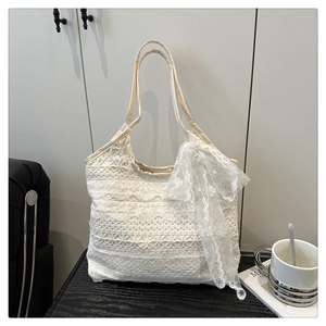 Detailed macro view of the delicate floral lace texture and ribbon on the tote bag