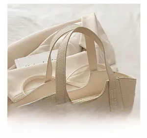 Dettaglio borsa a secchiello beige in pelle morbida con comoda impugnatura a doppio manico