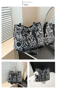 Close-up of large canvas tote bag with white graffiti art and metallic chain strap
