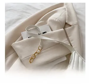 Close-up of white PU leather crescent bag featuring V-shaped quilting and gold chain strap