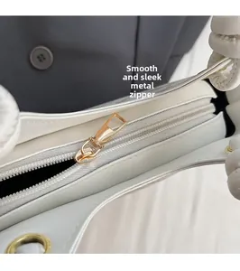 Gros plan du sac seau en cuir blanc avec fermeture éclair dorée fluide et coutures précises