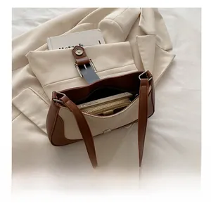 Interior capacity detail of brown leather and canvas bag showing phone and wallet storage