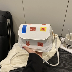 Borsa a sella bianca con stampe colorate di cartoni animati e tracolla regolabile