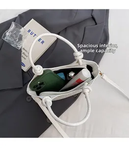 Vue détaillée de l'intérieur du sac seau blanc montrant l'espace pour mobile et maquillage