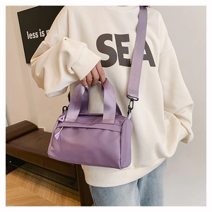 Détail du sac polochon en nylon violet avec sangle réglable et poche zippée cachée