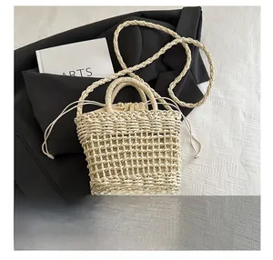 Detailed view of beige hollow-out woven straw bag with inner drawstring pouch and straps