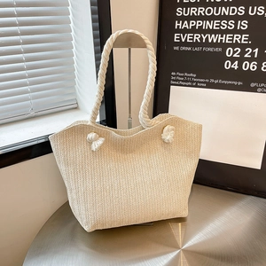 Large beige straw woven tote bag with white cotton rope handles and V-pattern texture