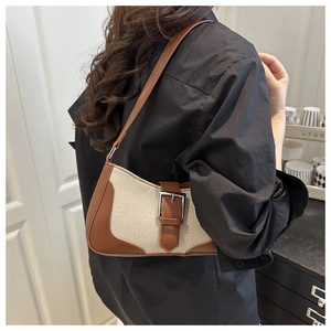 Close-up of retro canvas and brown leather shoulder bag with silver buckle details