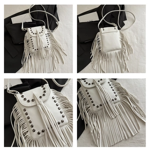 Detail of white leather crossbody bag with long tassels and metallic stud decorations