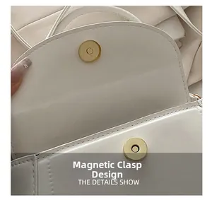 Detail view of the secure magnetic closure on this minimalist white leather handbag