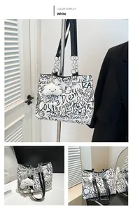 Detail view of graffiti tote bag with metal chain straps and plush cloud charm