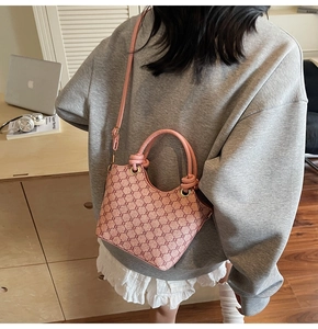 Vue arrière du mannequin portant un sac seau rose à monogramme avec poignée à nœud chez soi