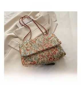 Detailed top view of a vintage floral embroidery crossbody bag with gold chain strap