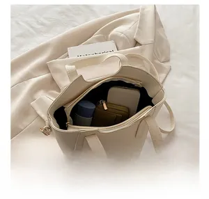 Vista interna che mostra la capacità della borsa beige in pelle a grana litchi