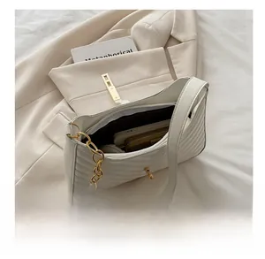 Detail showing internal capacity of cream quilted shoulder bag with phone and wallet