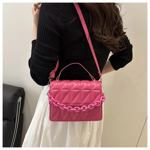 Détail du sac bandoulière matelassé rose avec chaîne en plastique et texture en cuir PU