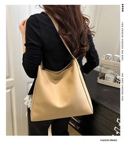 Minimalist beige tote bag with a large capacity shown from a side view on a model