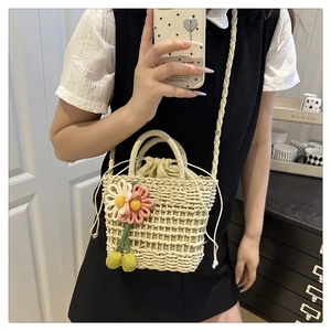 Detail view of woven straw bucket bag with floral 3D crochet and drawstring inner liner