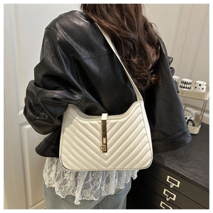 Close-up of a white V-quilted shoulder bag with a gold metal bar lock and CH logo detail