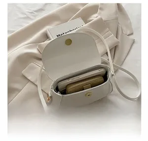 Internal capacity view of the white saddle bag showing storage for a phone and wallet