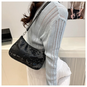 Detail of black embossed snake texture underarm bag with silver zipper and metallic buckle