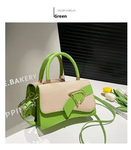 Detail of green PU leather and beige fabric contrast bag with gold triangle buckle