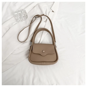 Top-down view of brown litchi pattern leather bag with flap and shoulder strap detail