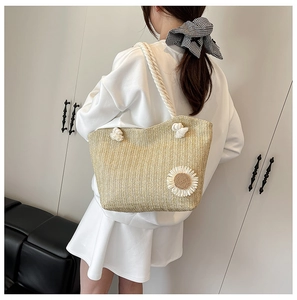 Close-up of beige woven tote bag featuring a 3D daisy flower and white rope handles