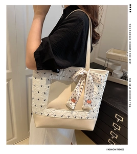 Détail du sac cabas matelassé crème avec motifs oiseaux et foulard décoratif à l'anse