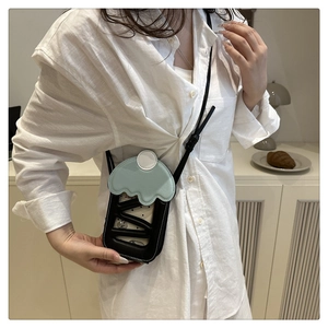 Detail of mint green ice cream shaped crossbody bag with black stitching and wavy lid