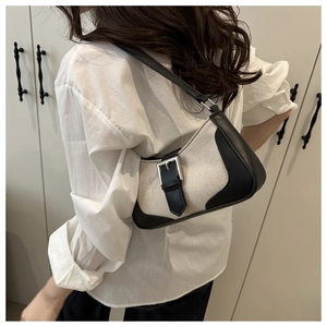 Detailed side view of vintage patchwork underarm bag with silver buckle on a model
