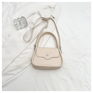 Detail of cream lychee texture handbag with elegant handle and matching buckle