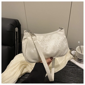 Detailed view of the white snakeskin textured shoulder bag with silver zipper hardware