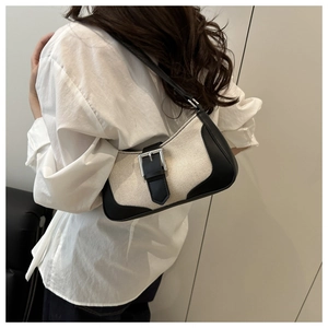 Detail of minimalist crescent bag with woven fabric, leather trim and silver buckle accent