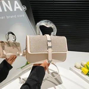 Creamy crossbody bag with rhinestone lid and metallic top handle for summer 2025
