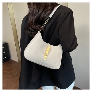 Detailopname van de crèmekleurige hobo-tas met gouden gesp en ketting aan de schouder