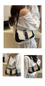 Detail of vintage canvas and black leather baguette bag with silver metal buckle
