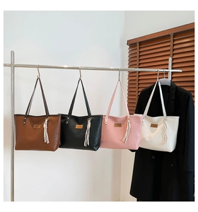 Detailed row of woven texture tote bags in brown black pink and white on a display