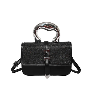 Black sequined flap handbag with fluid metal handle and heart pendant cross-body strap