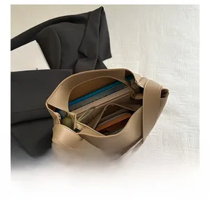 Top view showing large capacity of the beige tote bag with books, wallet and umbrella