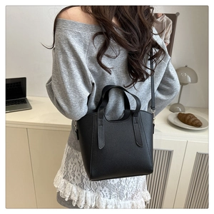 Chic black lychee texture leather tote bag worn as a stylish shoulder bag for daily life
