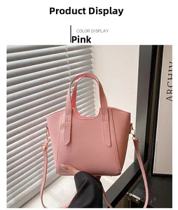 Dettaglio borsa a mano in pelle martellata rosa con doppi manici e finiture dorate