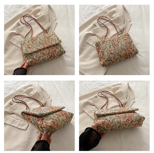 Detail of vintage floral jacquard shoulder bag featuring red metal chain strap and flap