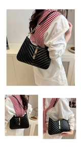 Detail of black leather hobo bag with V-shaped quilting and golden piston clasp buckle