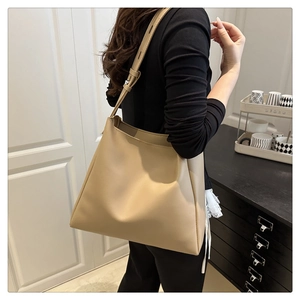 Minimalist beige tote bag shown from side back view on model for daily commuting